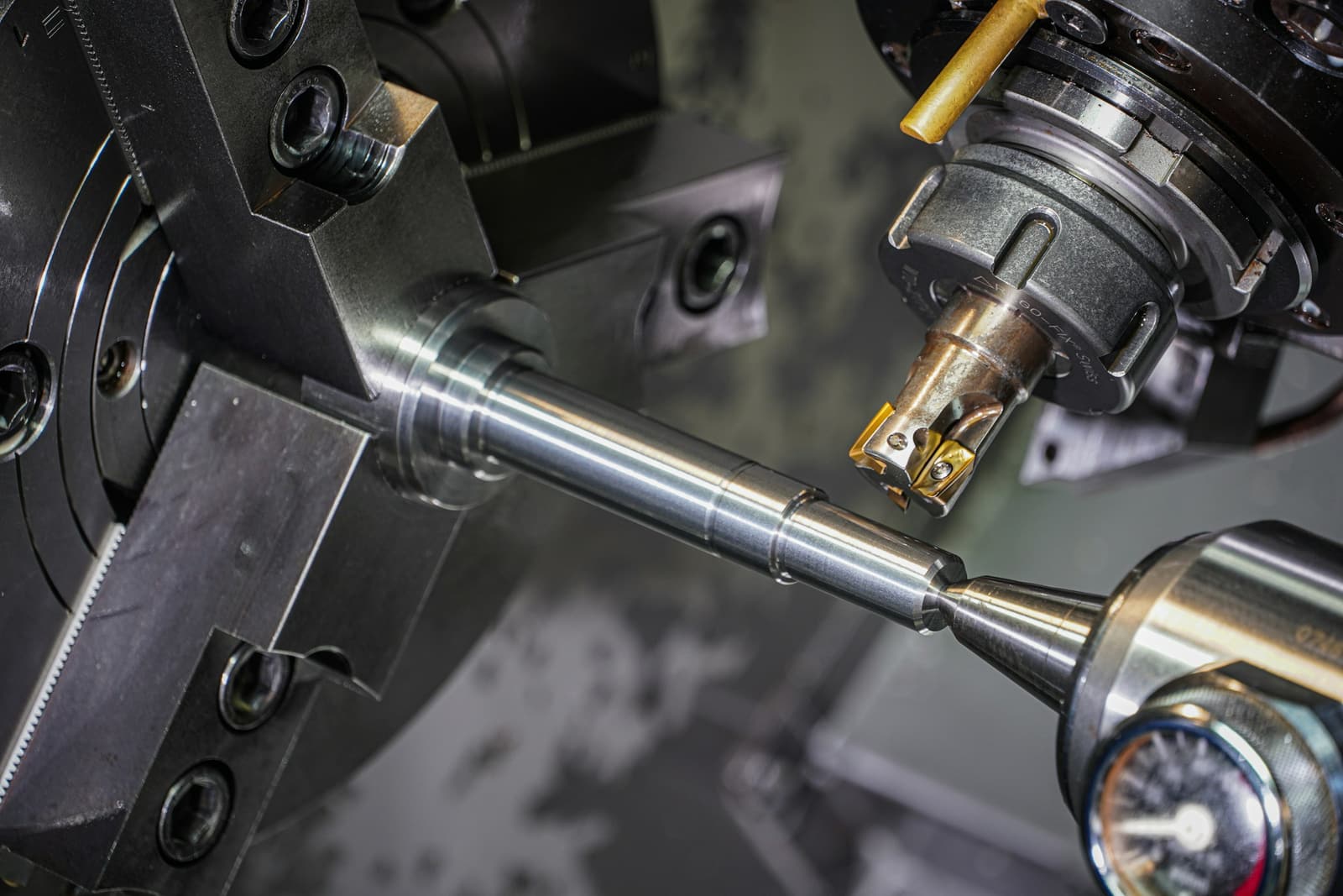 A steel rod held in a lathe chuck while a cutting tool turns it to size